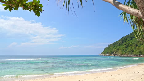 hidden tropical sandy beach and lagoon with green vegetation, turquoise sea and light waves on sunny day