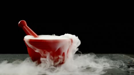 humo de hielo en mortero y pestillo contra un fondo negro 4k