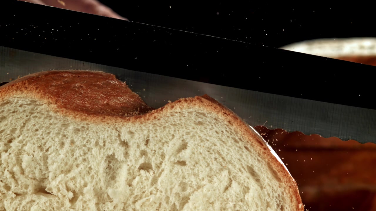 Slow Motion Slicing of Freshly Baked Bread with a Knife