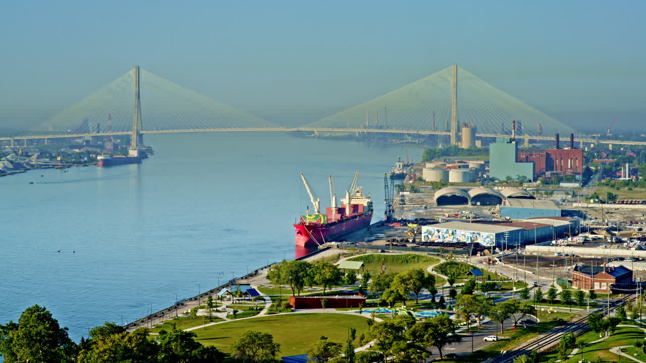 Scenic drone view of Detroit River with city skyline and large freighter making its way downstream