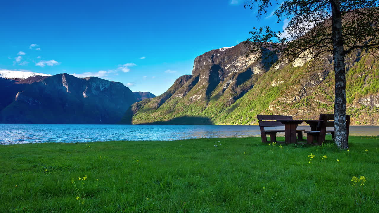 una mesa de picnic junto a un pintoresco fiordo en las montañas escandinavas - lapso de tiempo