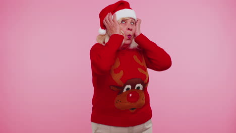 Grandmother-in-New-Year-deer-sweater-raising-hands-in-surprise-shocked-by-sudden-victory-wow-emotion