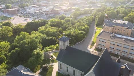 catholic church with belltower slowly reveals the surrounding small community is this song is setting over the horizon