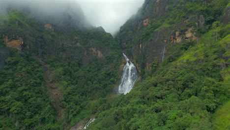 rising establishing aerial drone shot of ravana falls on misty day