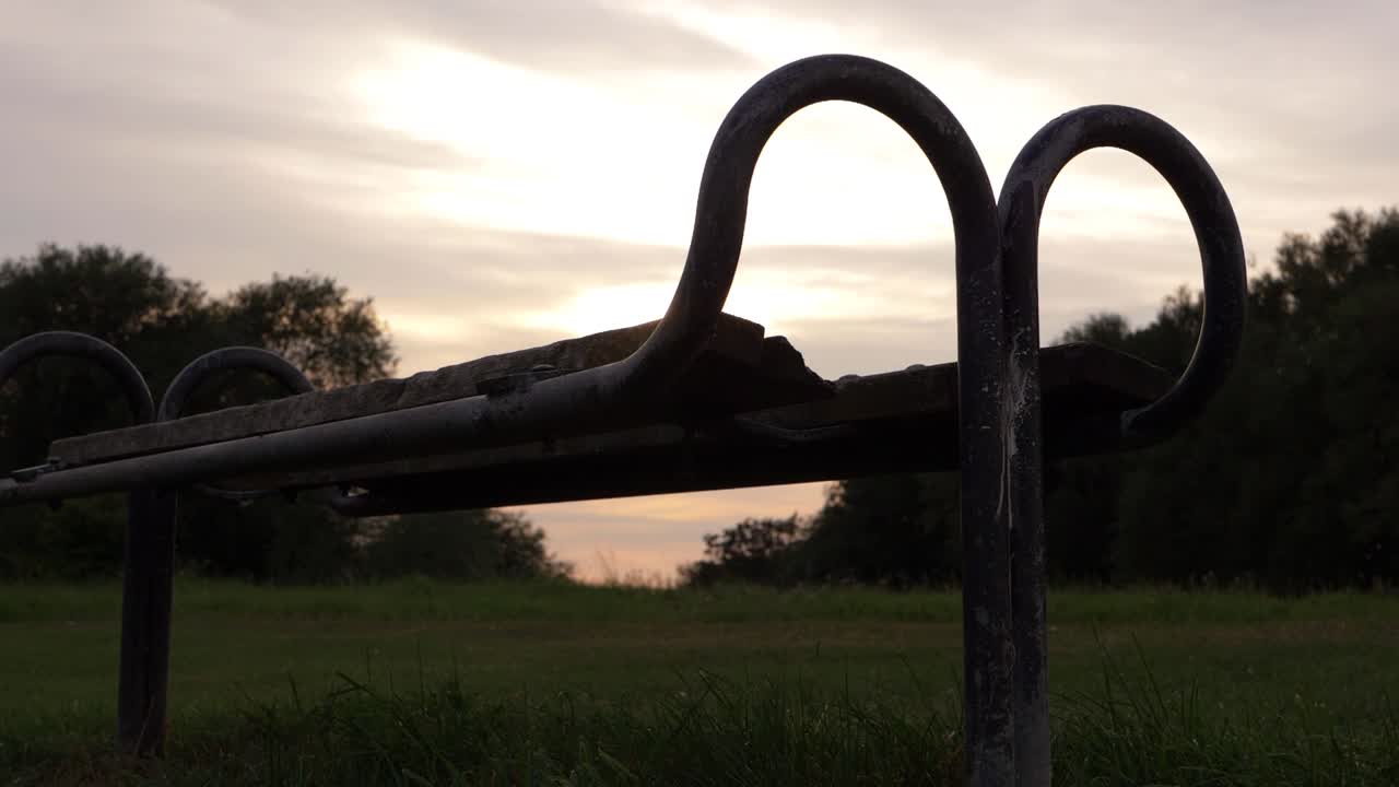 Lonely wooden park bench at sunset medium crane shot