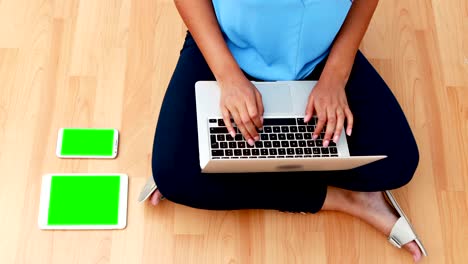 mujer ejecutiva usando una computadora portátil mientras estaba sentada en el suelo de madera 4k