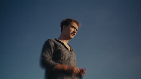 a contemplative man under a blue sky