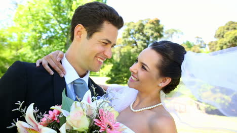 Happy-newlyweds-standing-in-the-park