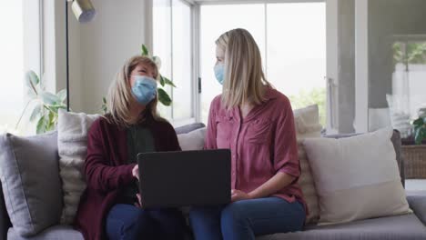 mother and daughter using laptop at home