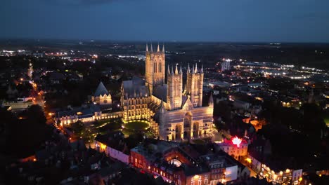 Aerial-drone-video-captures-the-renowned-Lincoln-Cathedral-in-Lincolnshire,-UK,-at-dusk,-emphasizing-its-illuminated,-grand-Gothic-architecture