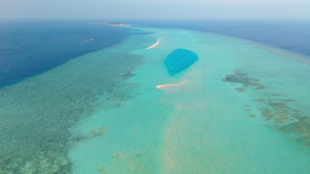 A stunning aerial drone view captures the pristine Rasdhoo Sandbanks surrounded by crystal-clear turquoise waters in the Maldives.