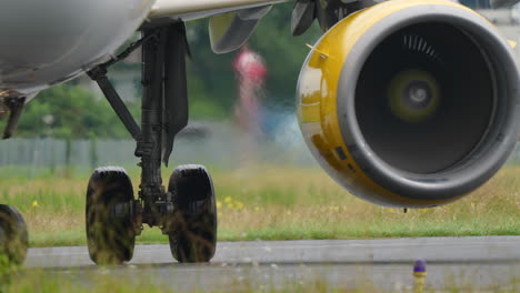 close-up view of an aircraft engine with yellow casing and wheel on runway, highlighting engineering details and aviation mechanics
