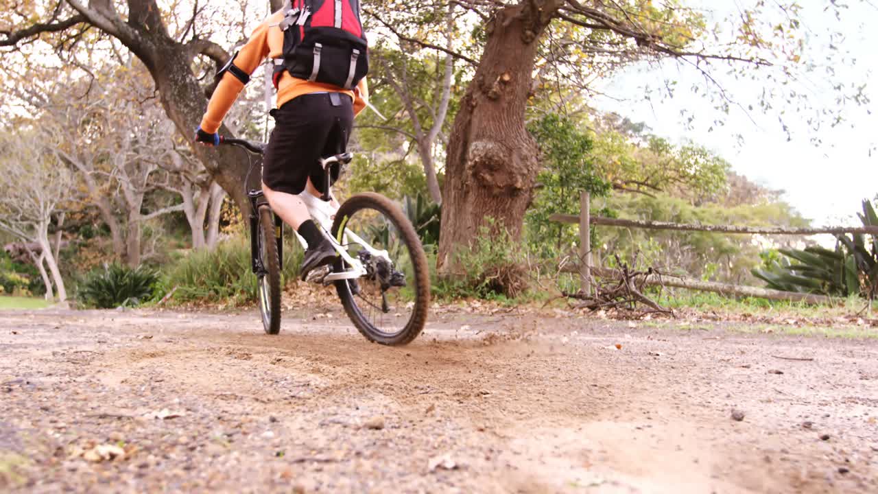 motociclista de montaña masculino montando en el bosque