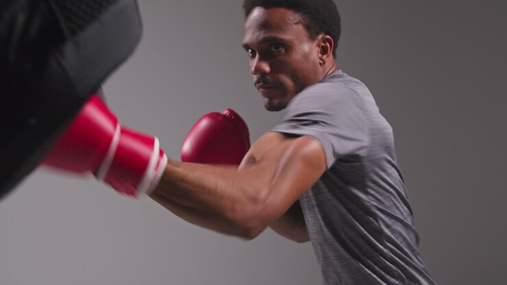 Studio Shot Of Male Boxer Sparring Working Out With Trainer Wearing Punch Mitts Or Gloves Practising For Fight 6