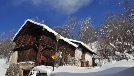 time lapse of an old wooden chalet - barn in the french alps with clouds passing by on a blue sky