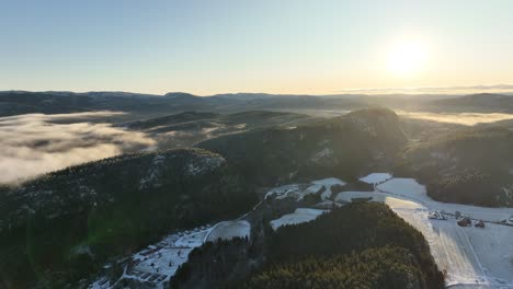 sunrise drone aerial shot flying over snowy landscape in norway