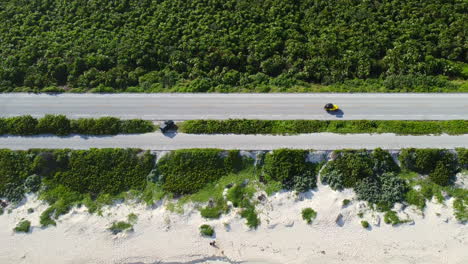 Antena-De-Arriba-Hacia-Abajo-Del-Vehículo-Amarillo-Que-Conduce-Por-La-Carretera-Costera-En-Cozumel-México