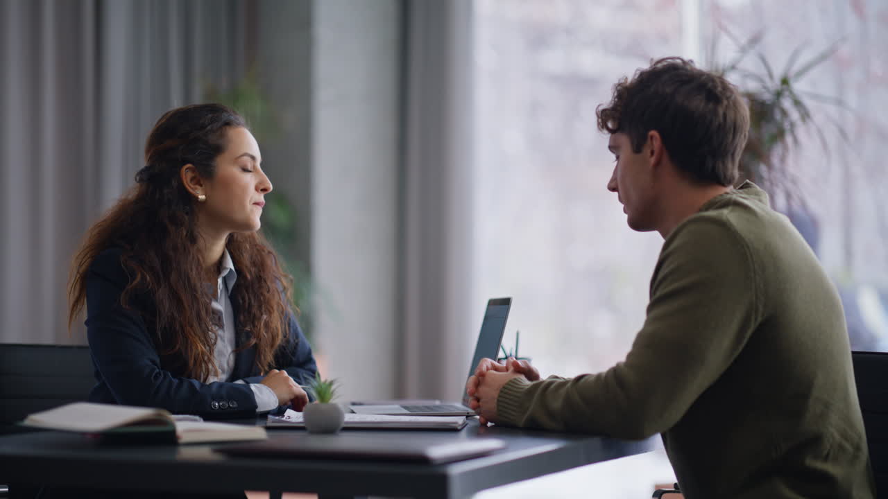 Primo piano di un manager sorridente che consulta un cliente su un contratto alla scrivania dell'ufficio aziendale