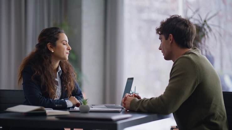 Smiling manager consulting client on contract at company office desk closeup