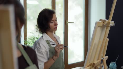 Female-students-painting-at-art-lesson-in-art-studio