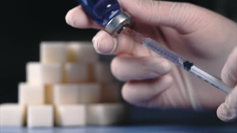 administering an injection with sugar cubes in background