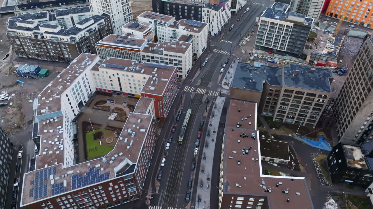 Aerial view rotating in front of a tram on the streets of Helsinki, cloudy day