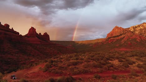 dramatic sunset sky with clouds and rainbow over red rocks landscape in sedona, arizona, usa