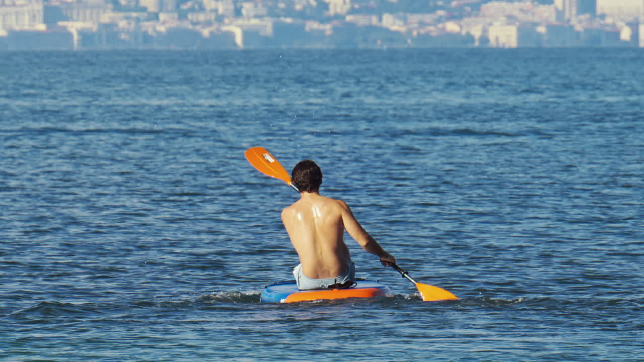 Antibes, France - May 2, 2025: A man and a woman sitting on a board, paddling on the sea