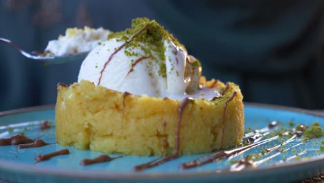 close-up of a delicious turkish dessert with ice cream, pistachios, and chocolate syrup