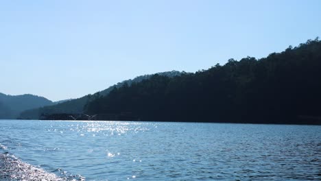 boat traversing a calm, scenic lake