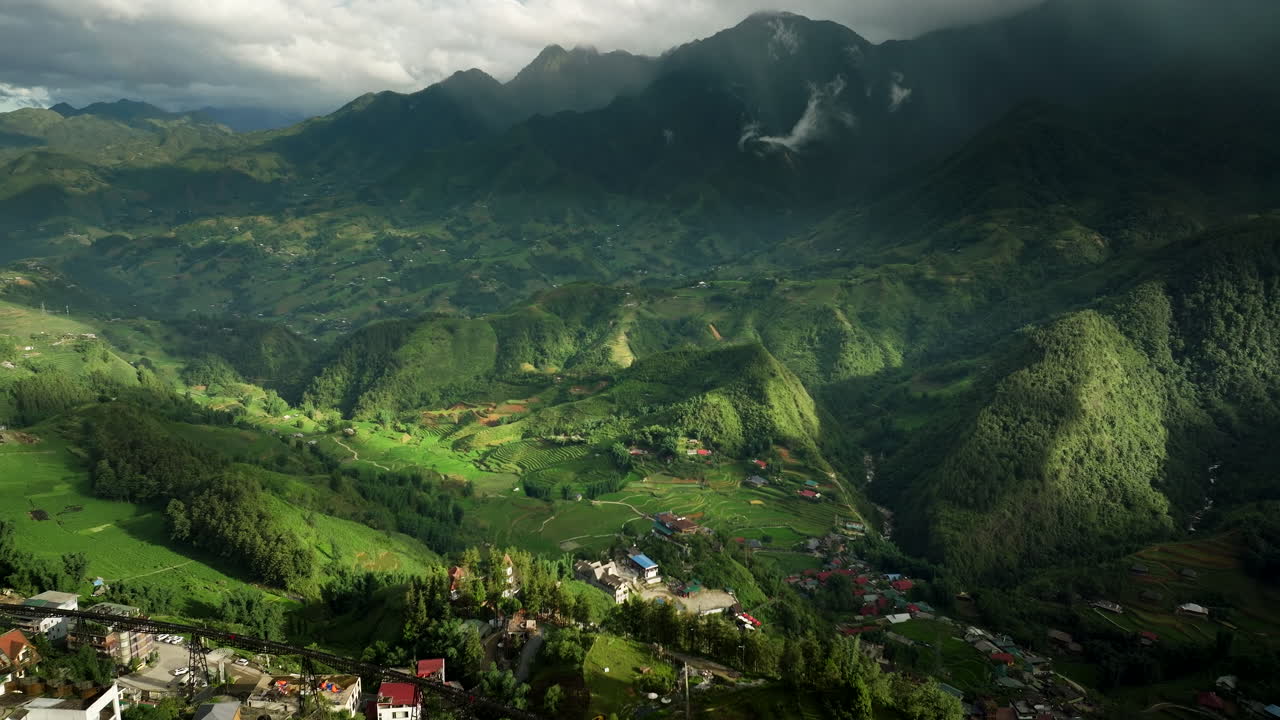 Drone view of Sapa Valley’s rice terraces with foggy mountains in the distance, tranquil scene