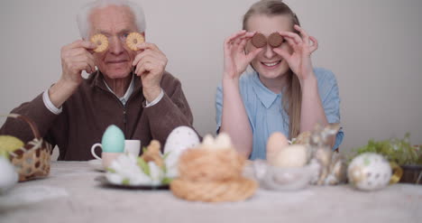 senior man smiling chererful grandfather and granddaughter playing with cakes and smile