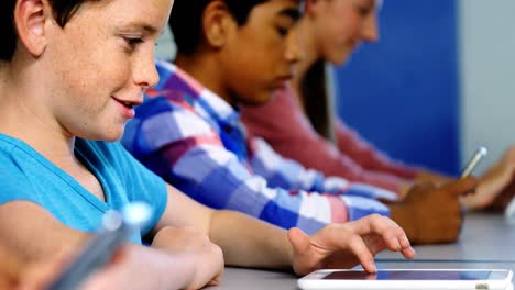 Students using digital tablet and mobile phone in classroom
