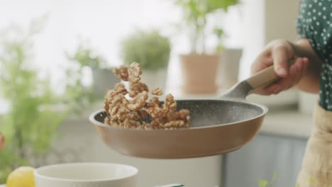 Persona-Anónima-Freír-Nueces-En-Una-Sartén-En-La-Cocina