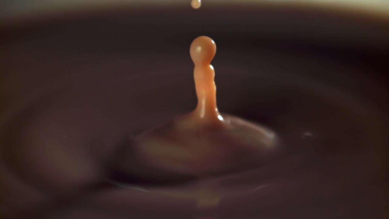 Goccia di liquido marrone cremoso che schizza al rallentatore