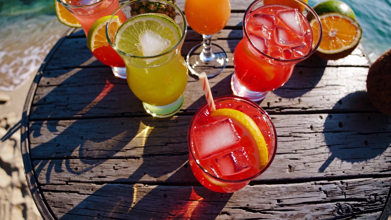 Farbenfrohe tropische Cocktails und frische Früchte auf einem rustikalen Strandtisch