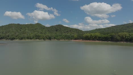 Flying-over-Aniana-Vargas-nature-reserve,-Hatillo-embankment-dam-on-Yuna-River-in-Dominican-Republic