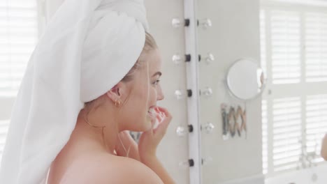 Happy-caucasian-plus-size-woman-in-front-of-mirror-with-towel-on-head-in-slow-motion