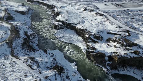 river from glacier runoff in snowy iceland landscape, cinematic aerial