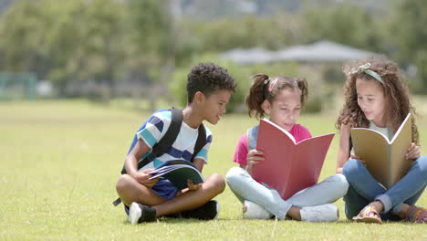 biracial children are engrossed in reading books outdoors in school