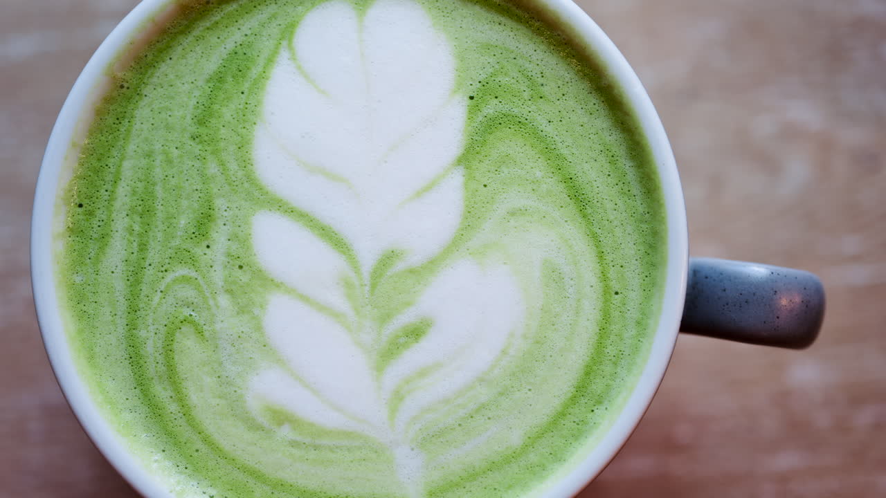 Close up of a matcha latte on a wooden table