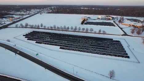 aerial view of field with solar panels covered in snow