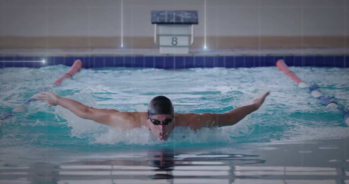 Swimmer pushing off lane eight and racing butterfly stroke in swim meet creating water splashes