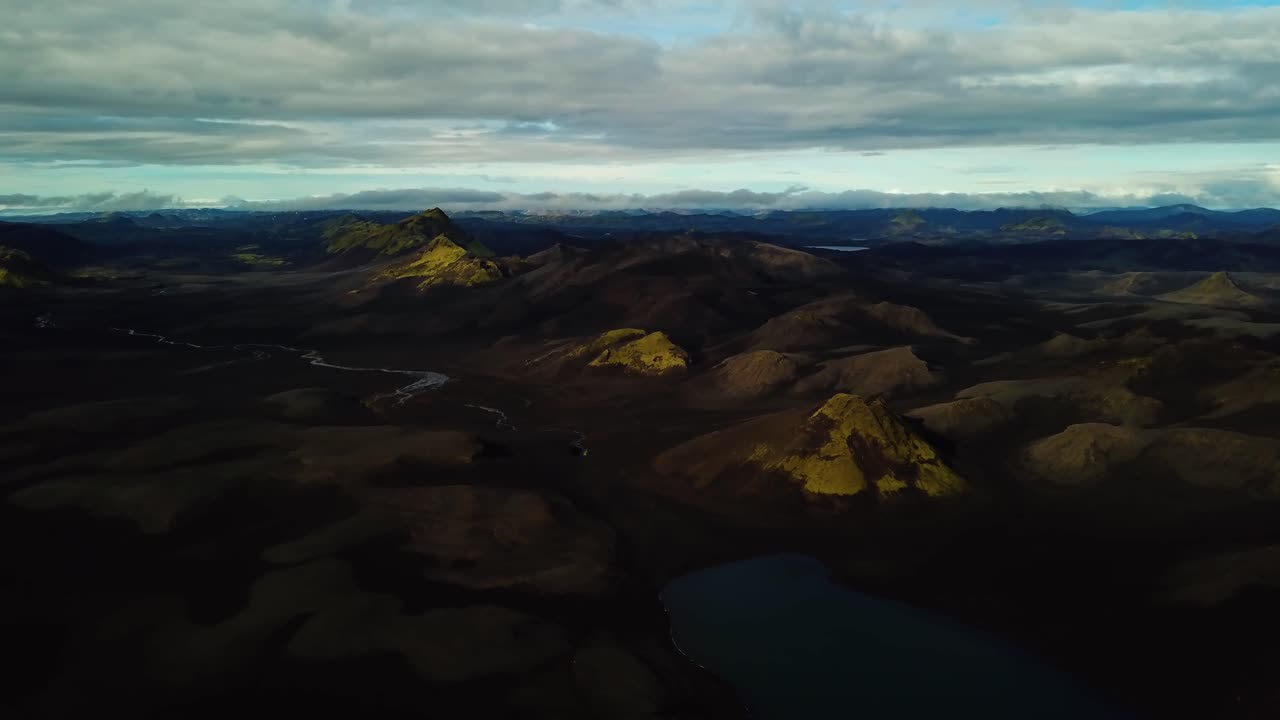 vista aérea del paisaje sobre las tierras altas islandesas, colinas y montañas oscuras, ríos y lagos, en un día nublado
