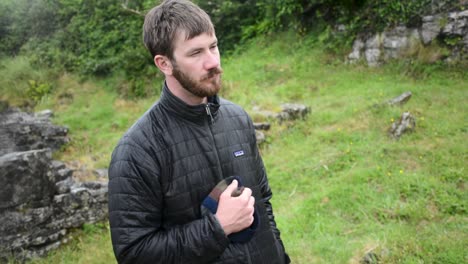 Serious-Looking-Middle-Aged-White-Man-With-Beard-Stand-in-the-Rain-Looking-to-the-Right