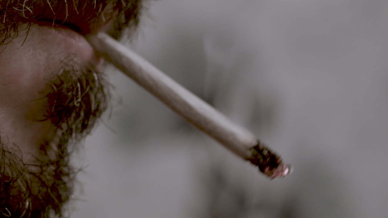 foto macro de un hombre enciende un cigarrillo hecho a mano