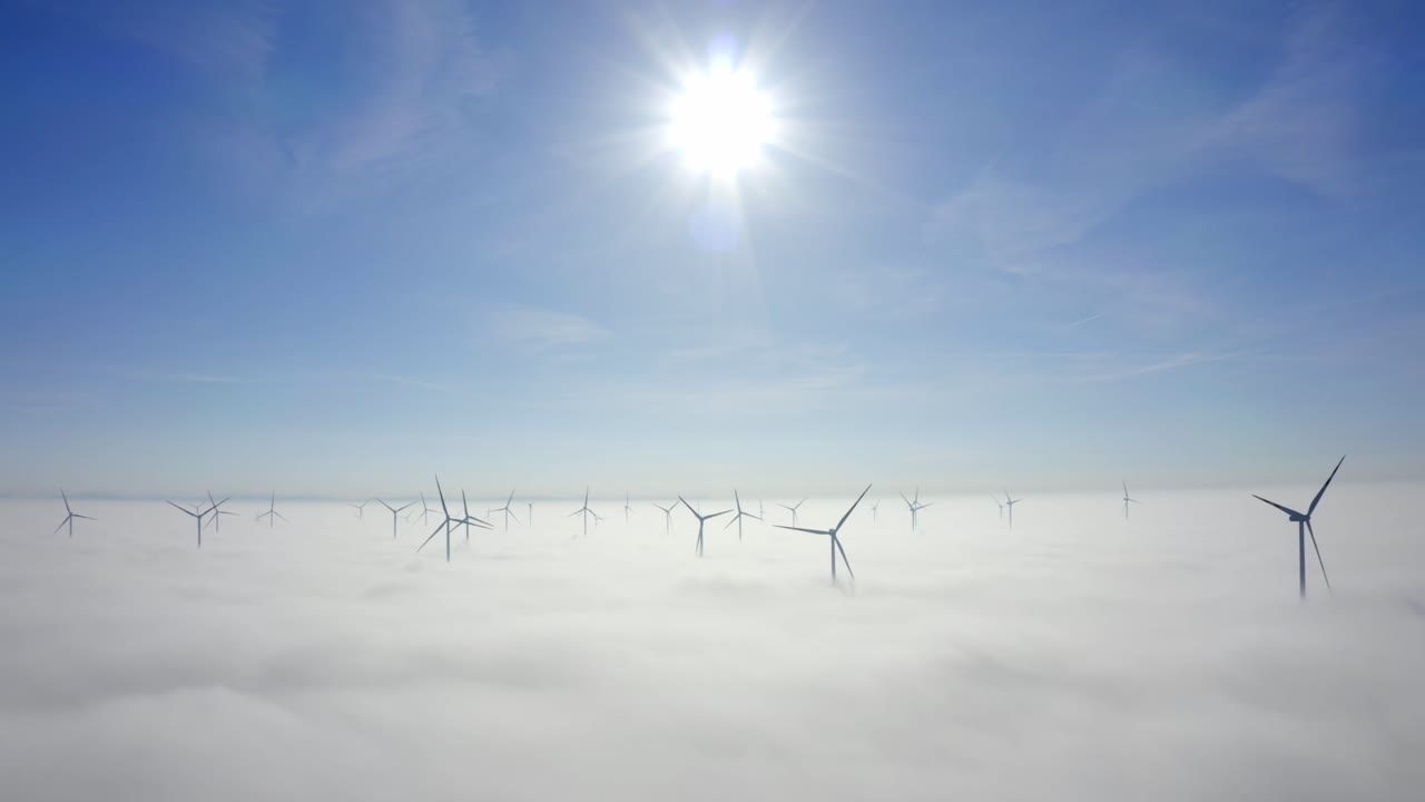 일출 동안 안개 속의 풍력 터빈