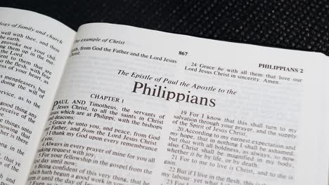 close up shot of bible page turning to the book of philippians