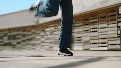 Cerca-De-Las-Piernas-Y-Los-Pies-De-Una-Joven-Feliz-Bailando-E-Improvisando-Movimientos-Usando-Zapatillas-En-Un-Piso-De-Concreto-En-Un-Día-Soleado-En-El-Parque-De-La-Ciudad