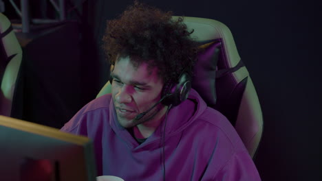 concentrated boy with headphones playing video games in a gaming club